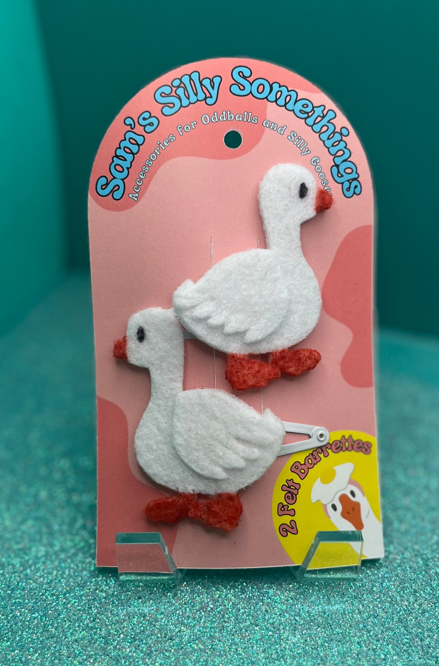 Packaged geese barrettes with 'Sam's Silly Somethings' branding on a teal background.