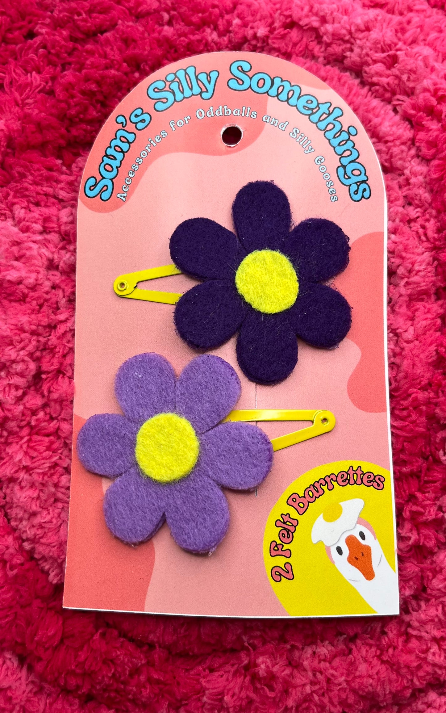 Flower-shaped hair clips on a pink card with 'Sami's Silly Somethings' branding against a pink textured background.