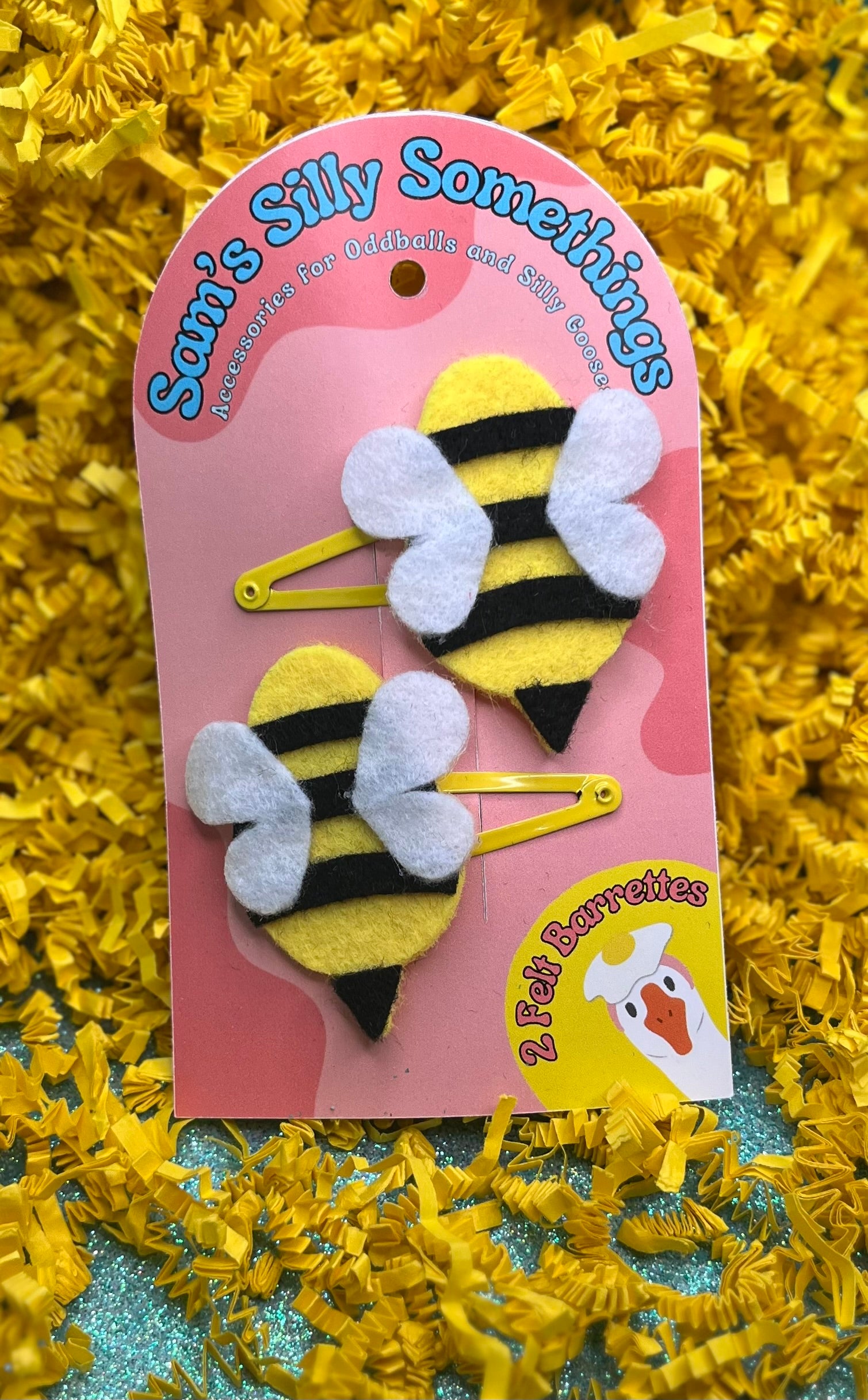 Two bee-shaped hair barrettes attached to a pink cardboard backing with the brand name 'Silly Somethings' written at the top.