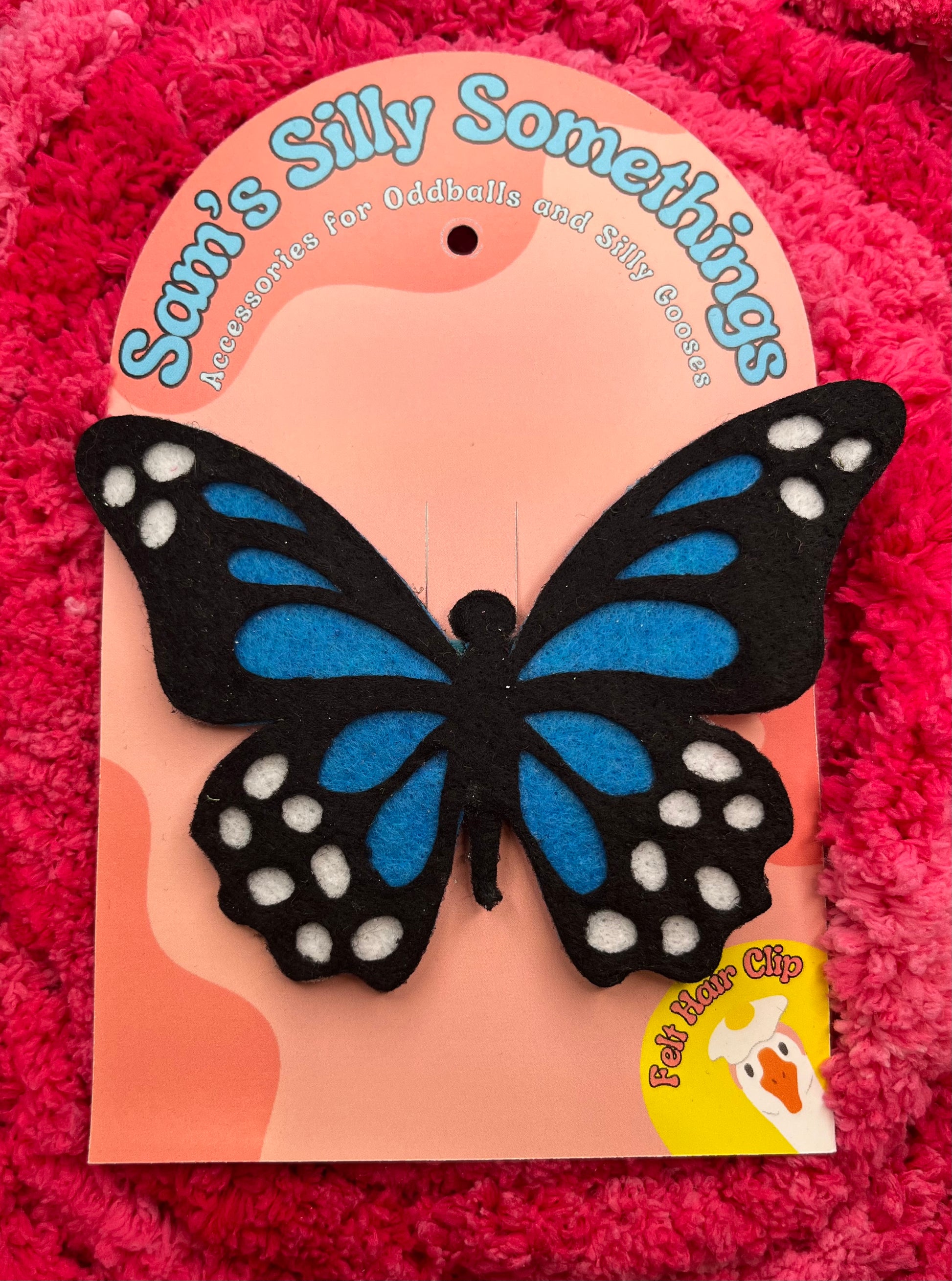 Butterfly-shaped product on a pink background with 'Sam's Silly Somethings' branding.