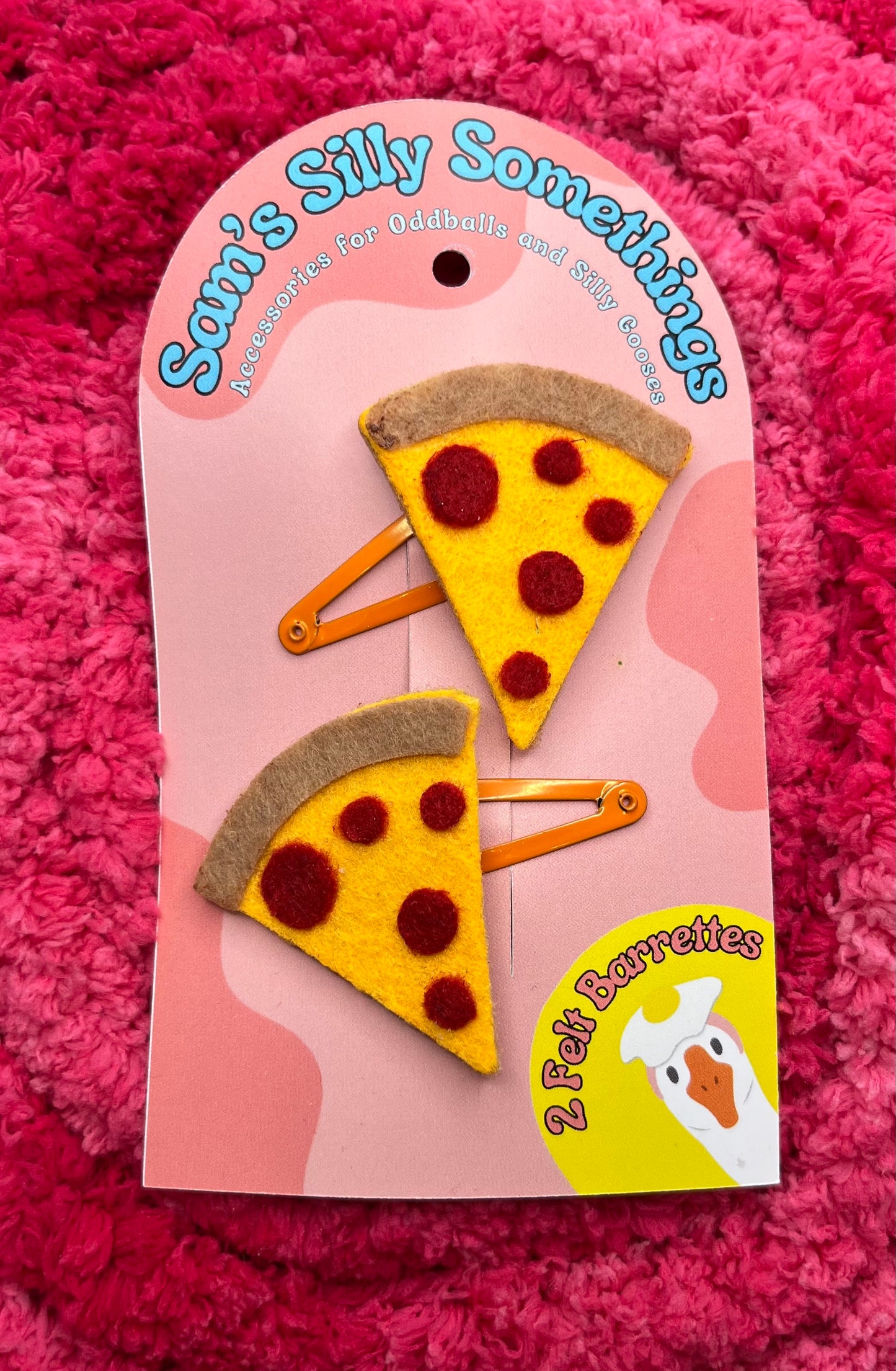 Pizza-shaped hair clips on a pink card with 'Sami's Silly Somethings' branding against a pink textured background.