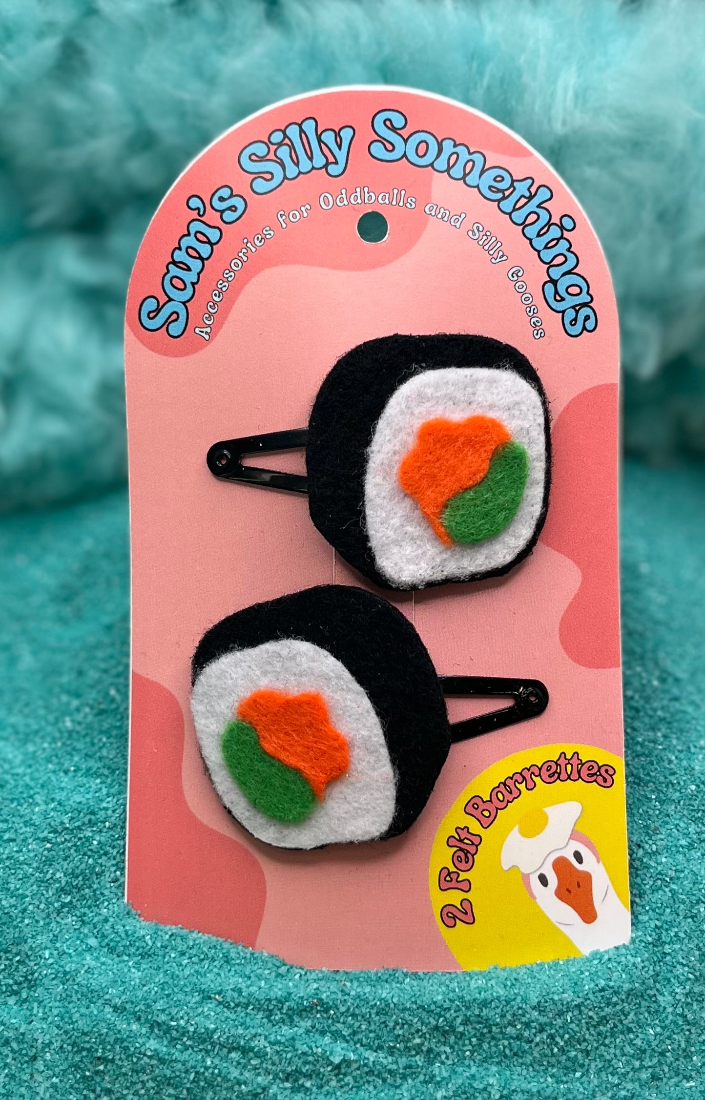 Two sushi-shaped hair barrettes attached to a pink card with the brand name 'Sam's Silly Somethings' written at the top.